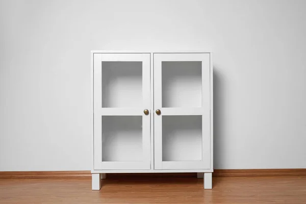 Empty wooden cabinet near white wall. Stylish home furniture