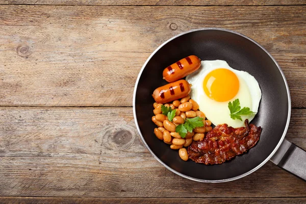 Sartén con desayuno inglés tradicional en mesa de madera, vista superior. Espacio para texto — Foto de Stock