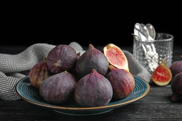 Placa con higos maduros sobre mesa de madera negra sobre fondo oscuro — Foto de Stock