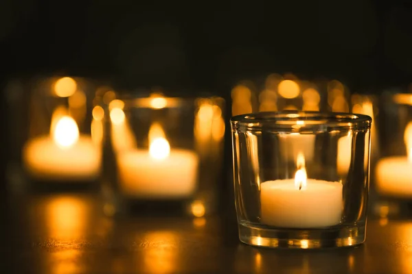 Queimar velas na mesa no escuro. Símbolo funerário — Fotografia de Stock