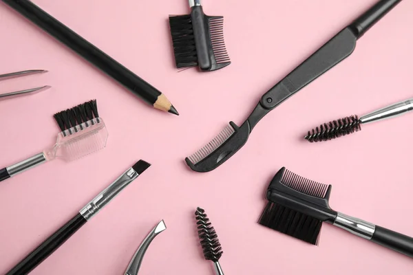 Conjunto de ferramentas de sobrancelha profissional sobre fundo rosa, flat lay — Fotografia de Stock