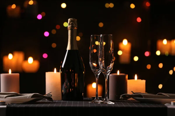 Cena romántica con velas encendidas y luces festivas — Foto de Stock