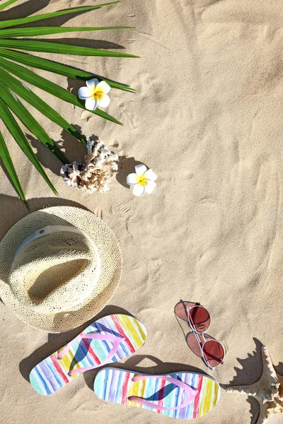 Composición plana con diferentes accesorios de playa sobre arena. Espacio para texto — Foto de Stock