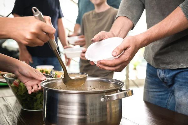 Voluntariado sirviendo comida a los pobres en el centro de caridad, primer plano — Foto de Stock