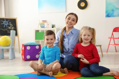 Oyun odasında çocukları olan anaokulu öğretmeni. İç mekan aktivitesi