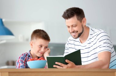 Baba ve oğlu mutfakta ilginç kitap okuyor