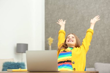 Mutlu genç kadın evde dizüstü bilgisayar kullanarak online piyango oynuyor