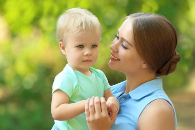 Yeşil parkta onu sevimli çocuk ile genç anne
