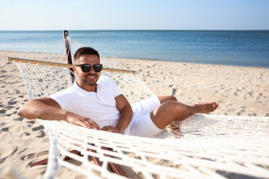 Sahilde hamakta dinlenen genç adam