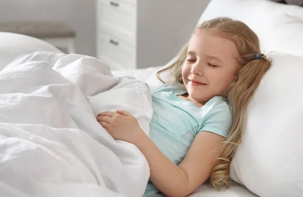 Portrét rozkošné holčičky spící na velké posteli — Stock fotografie