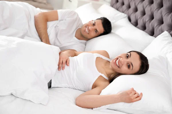 Adorável jovem casal descansando em grande cama confortável — Fotografia de Stock