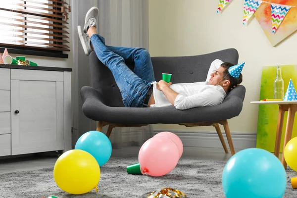 Man sover på soffan i stökigt rum efter fest — Stockfoto