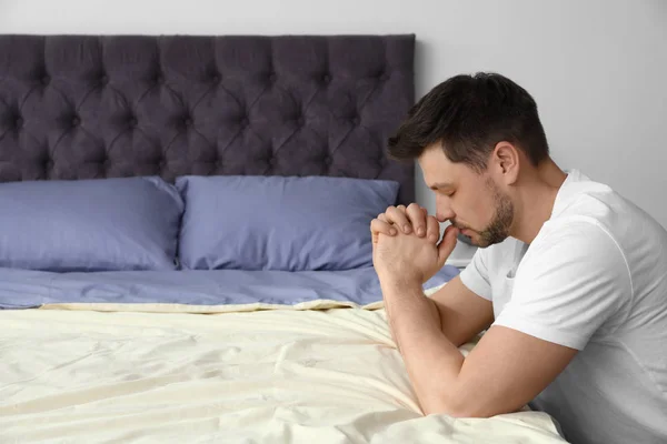 Красивый мужчина молится перед сном дома. Пространство для текста — стоковое фото