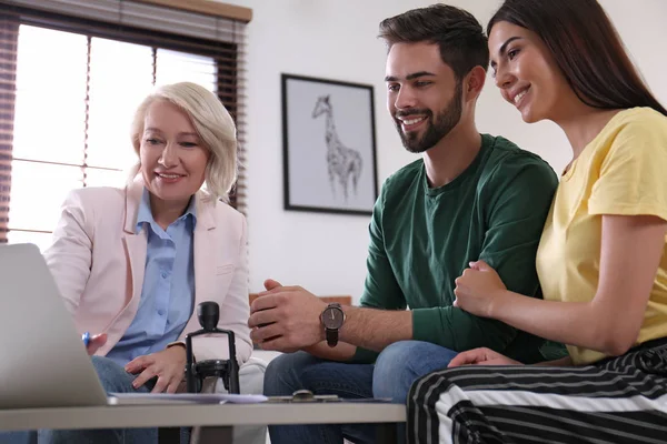 Vrouwelijke notaris werken met jong stel in Office — Stockfoto