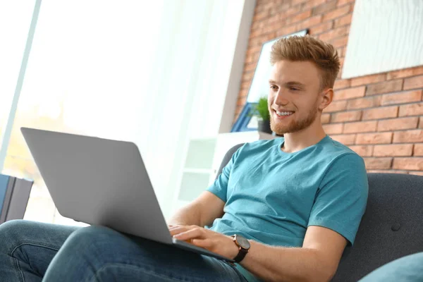 Junger Mann benutzt Laptop im Wohnzimmer — Stockfoto