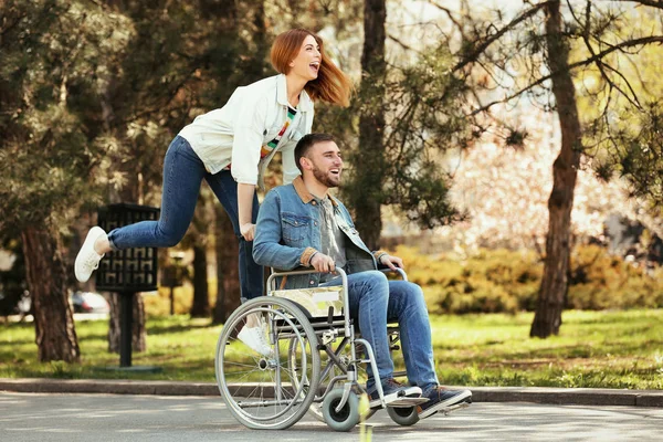 Jonge man in rolstoel en vrolijke vrouw in Park — Stockfoto