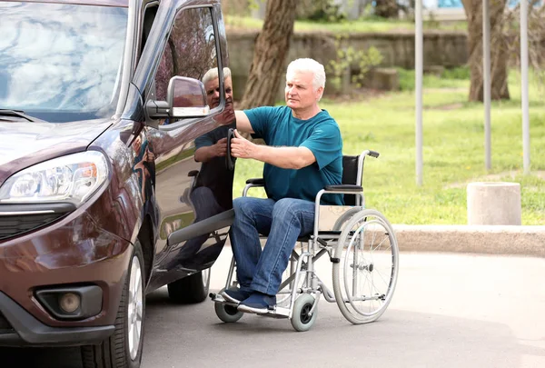 Dojrzały mężczyzna na wózku inwalidzkim drzwi jego van na dworze — Zdjęcie stockowe