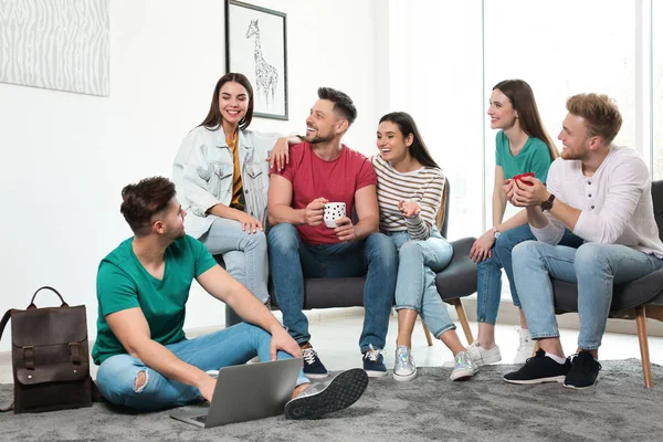 Grupo de personas felices con ordenador portátil en la sala de estar —  Fotos de Stock