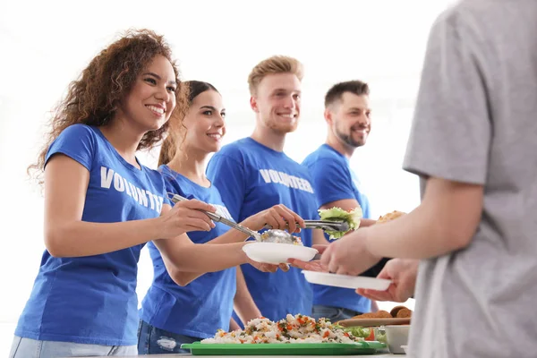 Voluntarios sirviendo comida a gente pobre en el interior — Foto de Stock