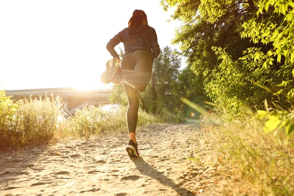 Junge Frau läuft an sonnigem Tag in Park — Stockfoto