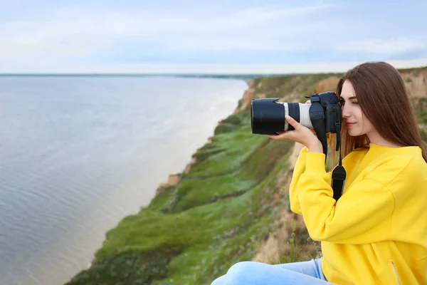 Kvinnlig fotograf tar bild av vackra landskap med professionell kamera på Green Hill. Utrymme för text — Stockfoto