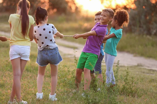 Bonito crianças brincando ao ar livre ao pôr do sol — Fotografia de Stock