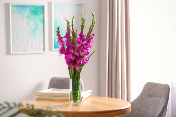 Vas dengan indah bunga gladiolus merah muda di atas meja kayu di kamar, ruang untuk teks — Stok Foto