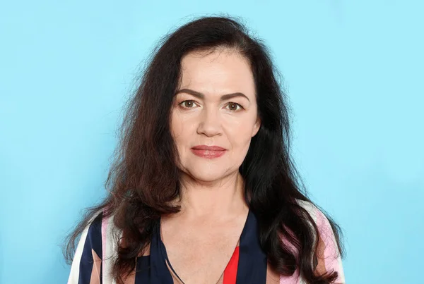 Porträtt av mogen kvinna med vackert ansikte på ljusblå bakgrund — Stockfoto
