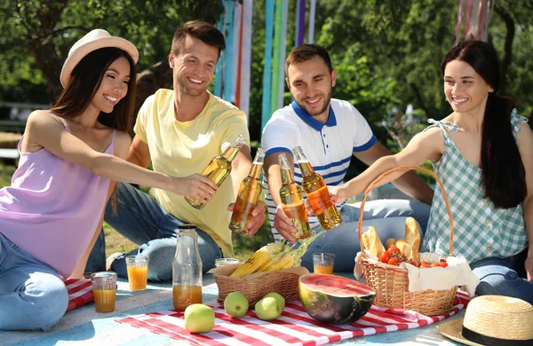 Jóvenes disfrutando de un picnic en el parque el día de verano —  Fotos de Stock