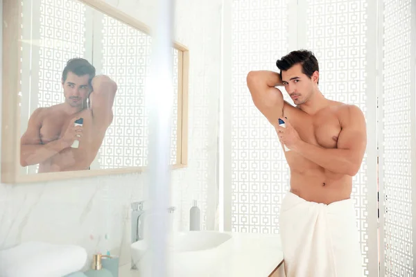 Csinos, fiatal férfi dezodor fürdőszobában alkalmazása — Stock Fotó