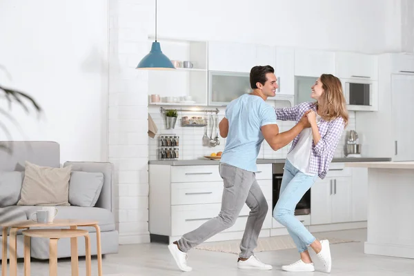 Belo jovem casal dançando na cozinha em casa — Fotografia de Stock