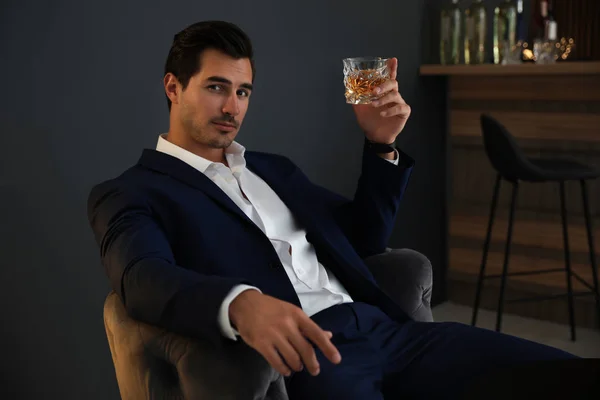 Jeune homme avec un verre de whisky au bar — Photo