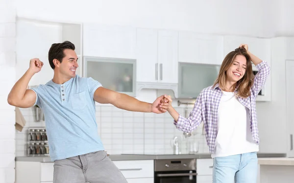 Beautiful young couple dancing in kitchen at home — Stock Photo, Image