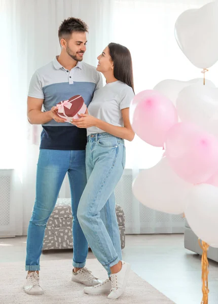 Junges Paar in einem mit Luftballons dekorierten Zimmer. Feier zum Valentinstag — Stockfoto