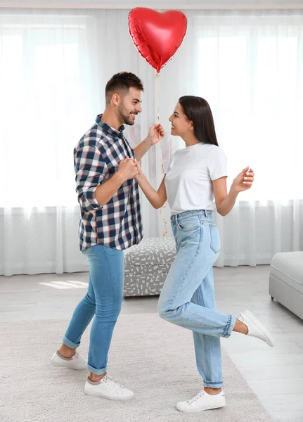 Junges Paar tanzt mit Luftballon zu Hause. Feier zum Valentinstag — Stockfoto