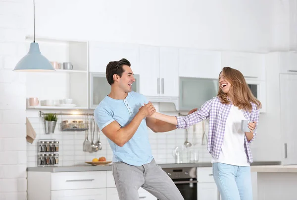 Belo jovem casal dançando na cozinha em casa — Fotografia de Stock