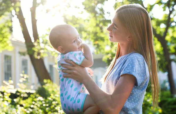 Teen nounou avec mignon bébé en plein air le jour ensoleillé — Photo