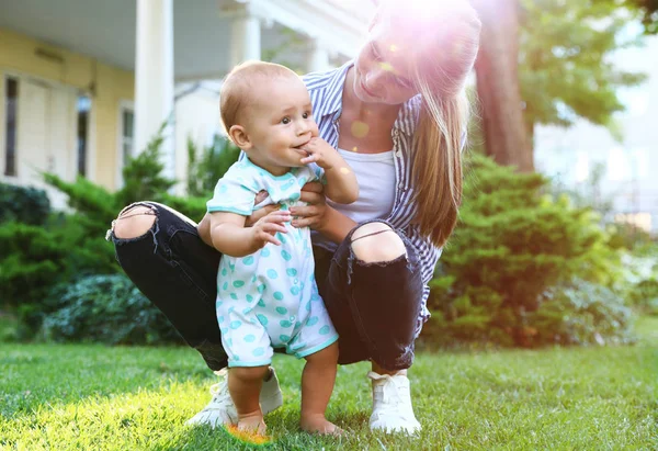 Teen nounou avec mignon bébé sur herbe verte à l'extérieur — Photo