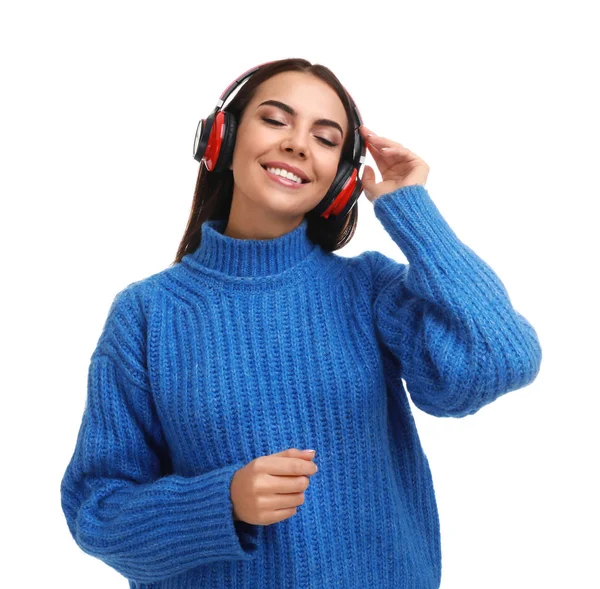 Молодая женщина слушает музыку с наушниками на белом фоне — стоковое фото