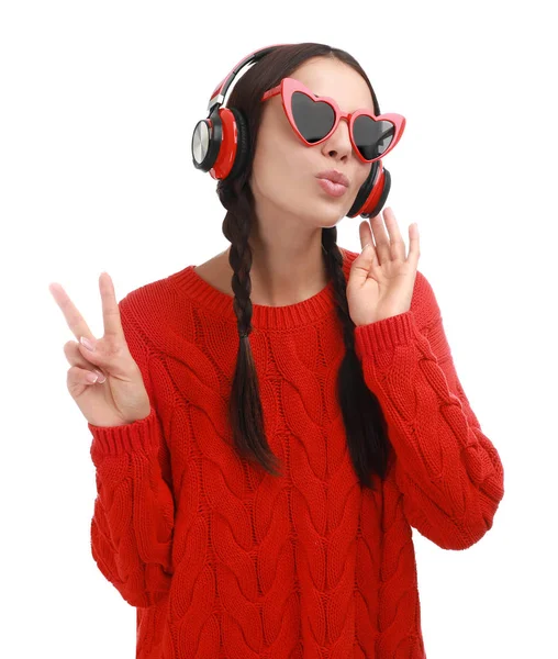 Молода жінка в окулярах у формі серця слухає музику на білому тлі — стокове фото