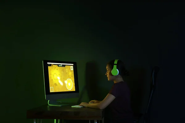 젊은 여자 와 헤드폰 재생 비디오 게임 에 어두운 방 — 스톡 사진