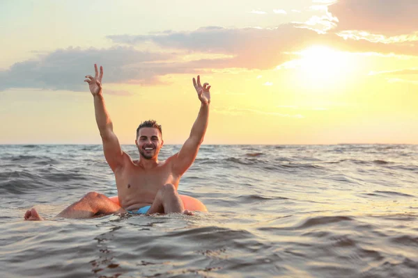 Feliz joven en el anillo inflable en el agua — Foto de Stock