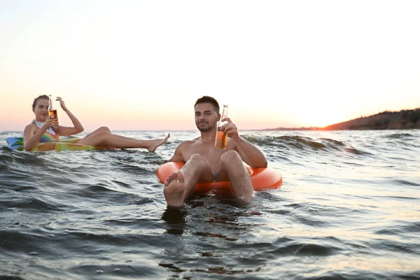 Feliz pareja joven en anillos inflables en agua — Foto de Stock