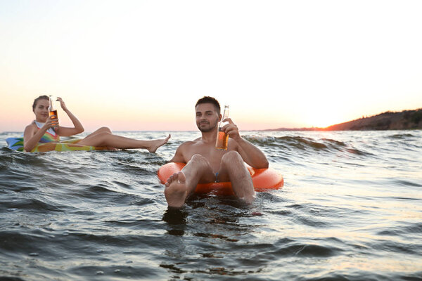 Happy young couple on inflatable rings in water