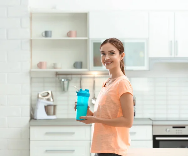 Athletische junge Frau mit Proteinshake in der Küche — Stockfoto