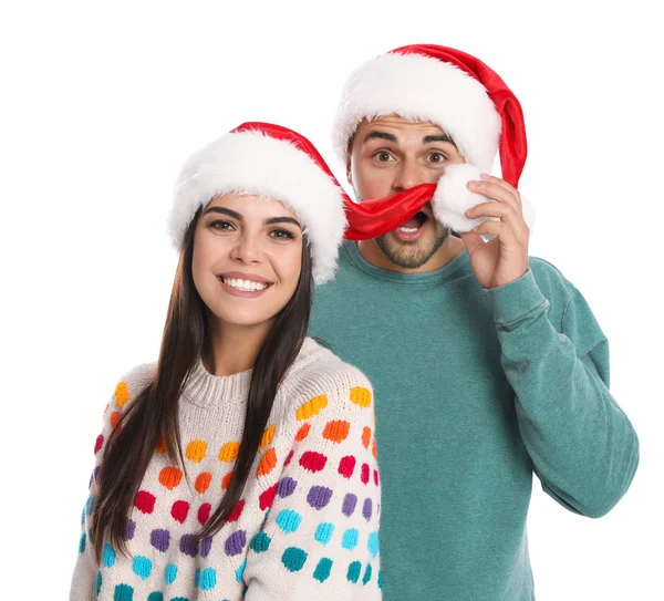 Casal jovem encantador em chapéus de Papai Noel no fundo branco. Celebração de Natal — Fotografia de Stock