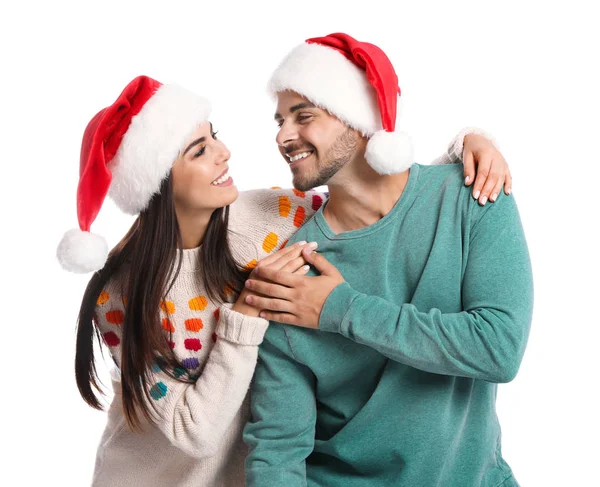 Casal jovem encantador em chapéus de Papai Noel no fundo branco. Celebração de Natal — Fotografia de Stock