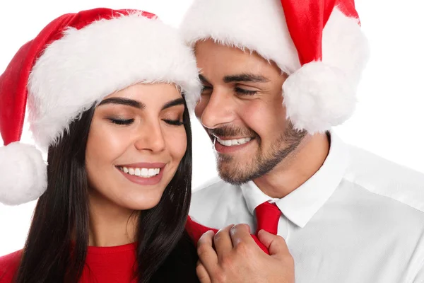 Bella giovane coppia in Babbo Natale cappelli su sfondo bianco, primo piano. Celebrazione di Natale — Foto Stock