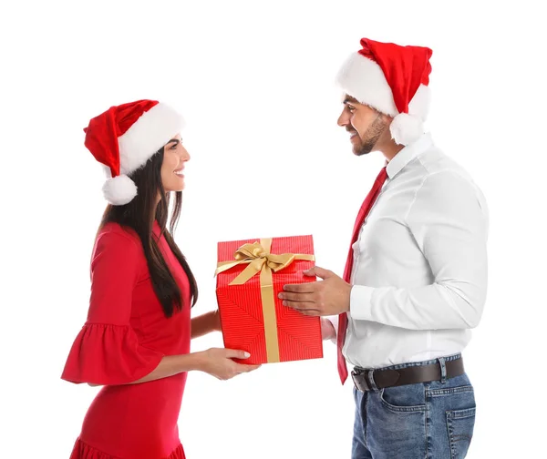 Encantador jovem casal em chapéus de Papai Noel com caixa de presente no fundo branco. Celebração de Natal — Fotografia de Stock