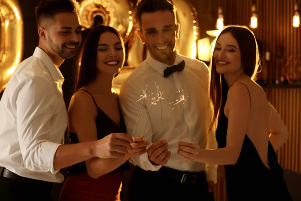 Young people celebrating New Year in club. Golden 2020 balloons on background Stock Picture